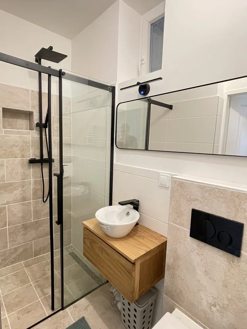 Bad nach der Sanierung mit Walk-in-Dusche und Holzwaschtisch